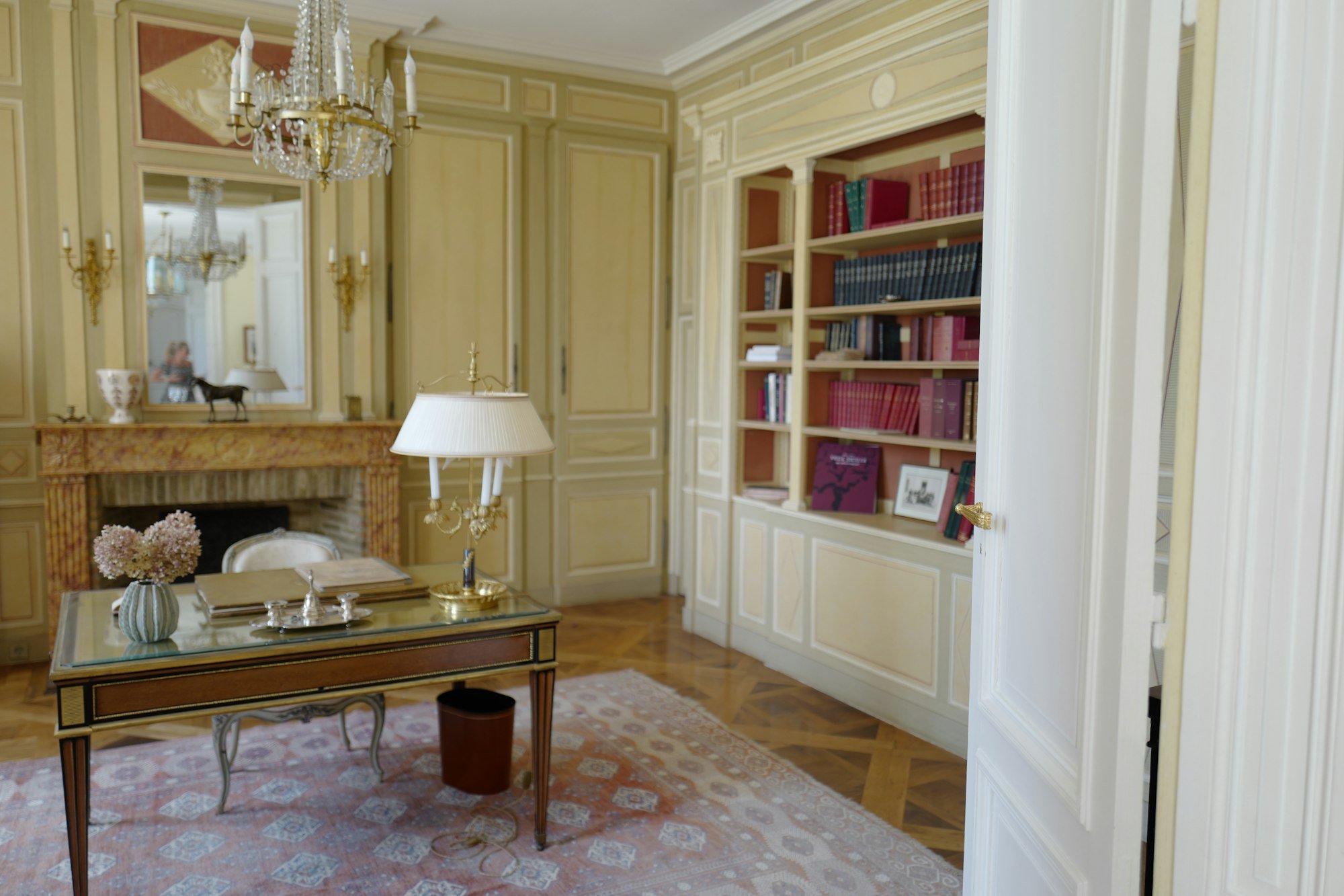 Un bureau lambrissé avec cheminée en marbre et bibliothèque intégrée