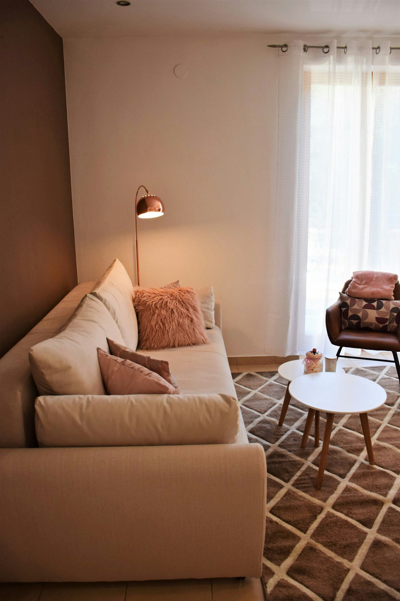 Un coin salon douillet avec un grand canapé et des coussins roses